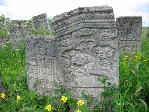 On a gravestone in Siret, Romania, a Crown flanked by griffins, above a lion