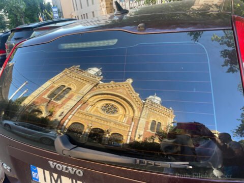 Fabric Synagogue în Timișoara, reflected în a parked car